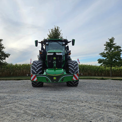 A John Deere TractorBumper 1000KG with LED lights is parked on gravel before a cornfield under cloudy skies, flanked by trees and Danish flags.